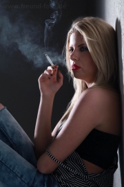 Frau raucht im Fotostudio