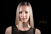 junge blonde Frau im dunklen Studio