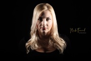 Junge blonde Frau im dunklen Studio