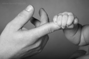 Kinderhand hält Papas Finger fest