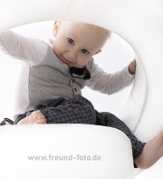 baby blickt durch hocker beim fotoshooting in nürnberg