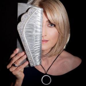 Frau blickt durch Clutsh Tasche