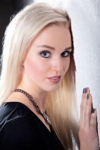 Junge blonde Frau an der Wand