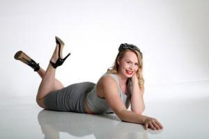 Junge Frau beim Fotoshooting liegt auf dem Lackboden