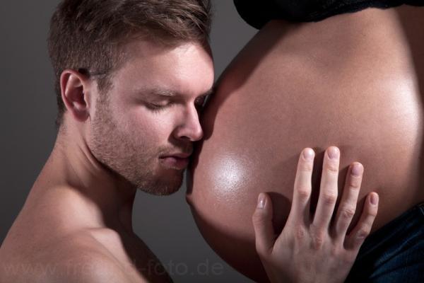Mann berührt sinnlich Babybauch von seiner Frau