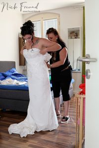 Braut zieht Brautkleid an